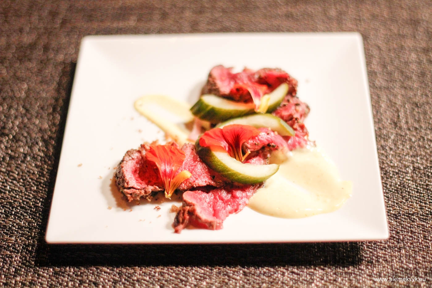 Tataki z polędwicy wołowej z piklowanym ogórkiem, pomarańczowym aioli, kruszonką z razowca i kwiatami nasturcji